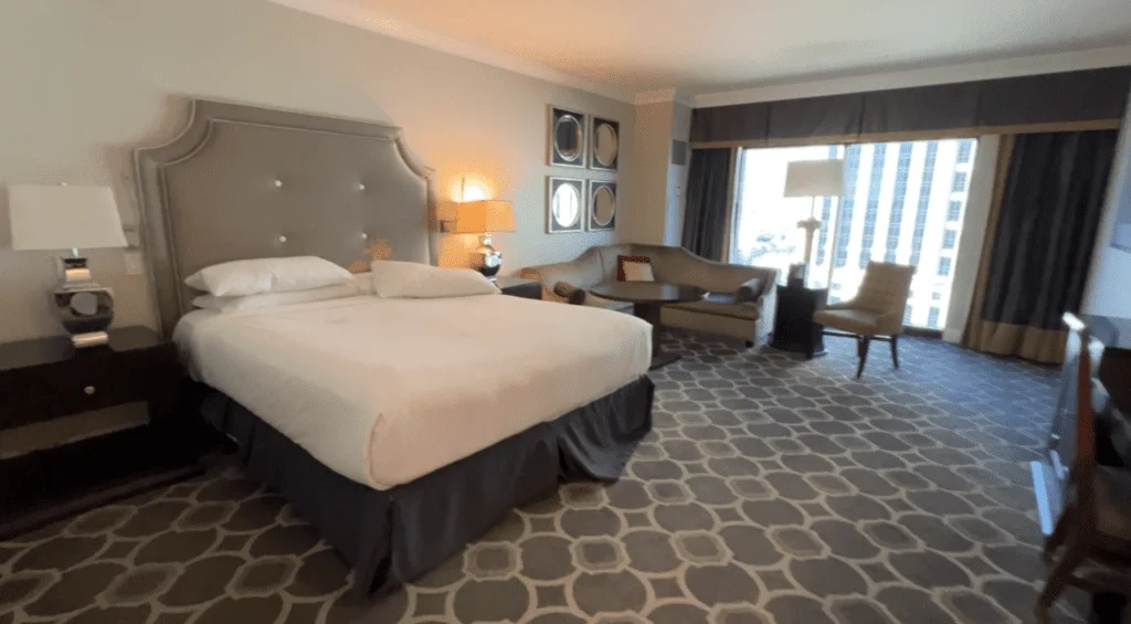 What It’s Like Staying at Caesars Palace Las Vegas - Still Cool? 18 Luxurious King Pool View room in the Octavius Tower, featuring a comfortable bed, L-shaped couch, and marble bathroom.